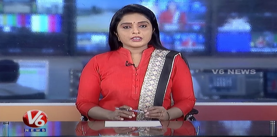 News anchor in red outfit presenting on V6 News channel.