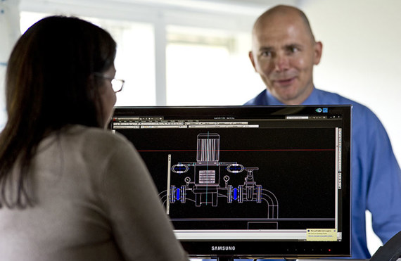 Two people discuss a technical design on a computer screen.