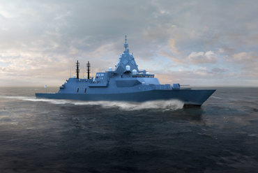 A modern warship cruising through the ocean under a cloudy sky.