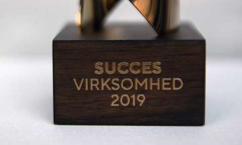 Trophy with "Succes Virksomhed 2019" engraved on wooden base.