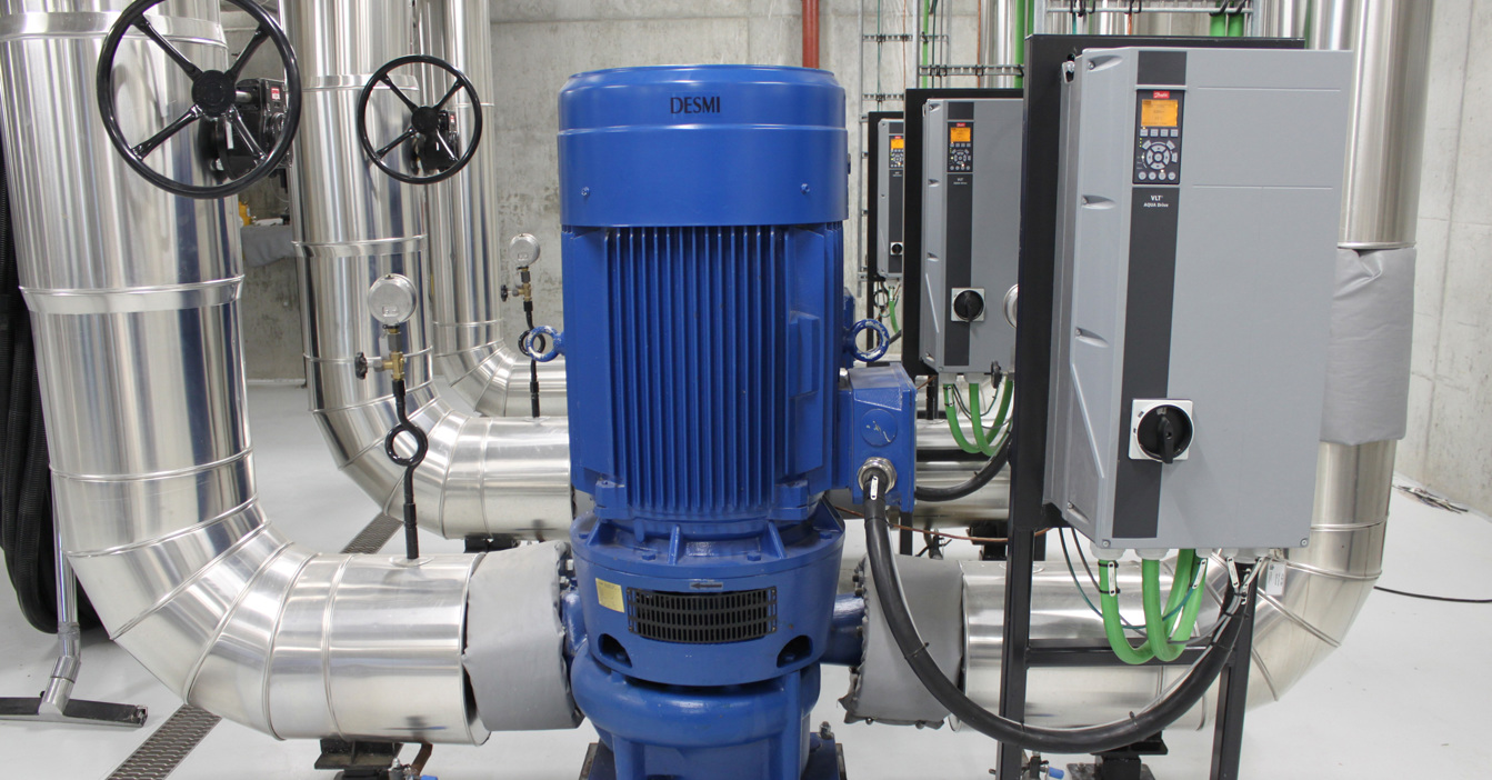 DESMI blue pump in an industrial setting with control panels and pipes.