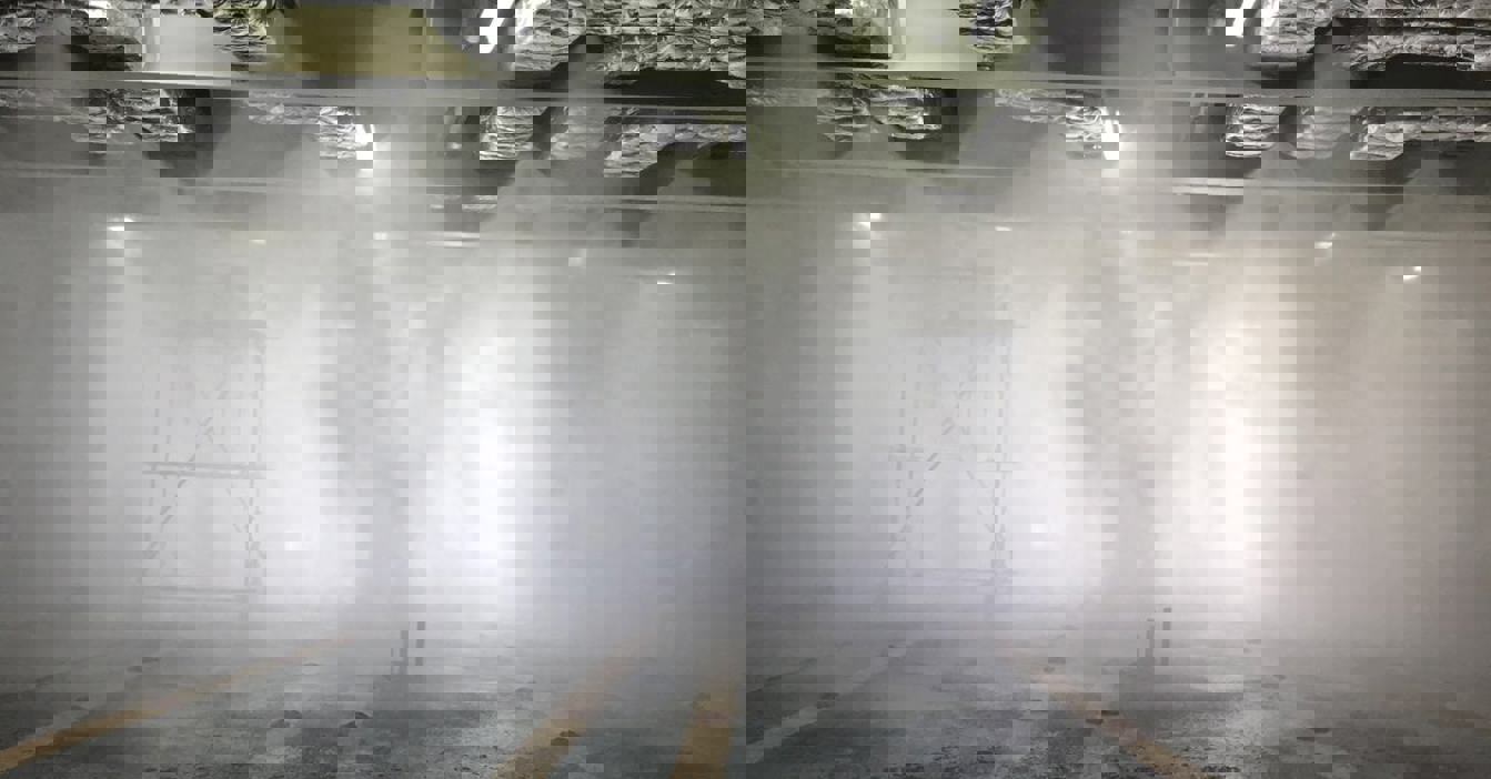 工业空间中，启用中的喷雾系统，背景中可见脚手架。