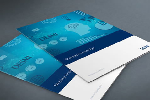 Blue and white DESMI brochures titled "Sharing Knowledge" on a gray surface.