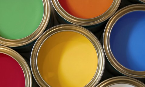 Open cans of paint displaying green, red, yellow, orange, and blue colors.