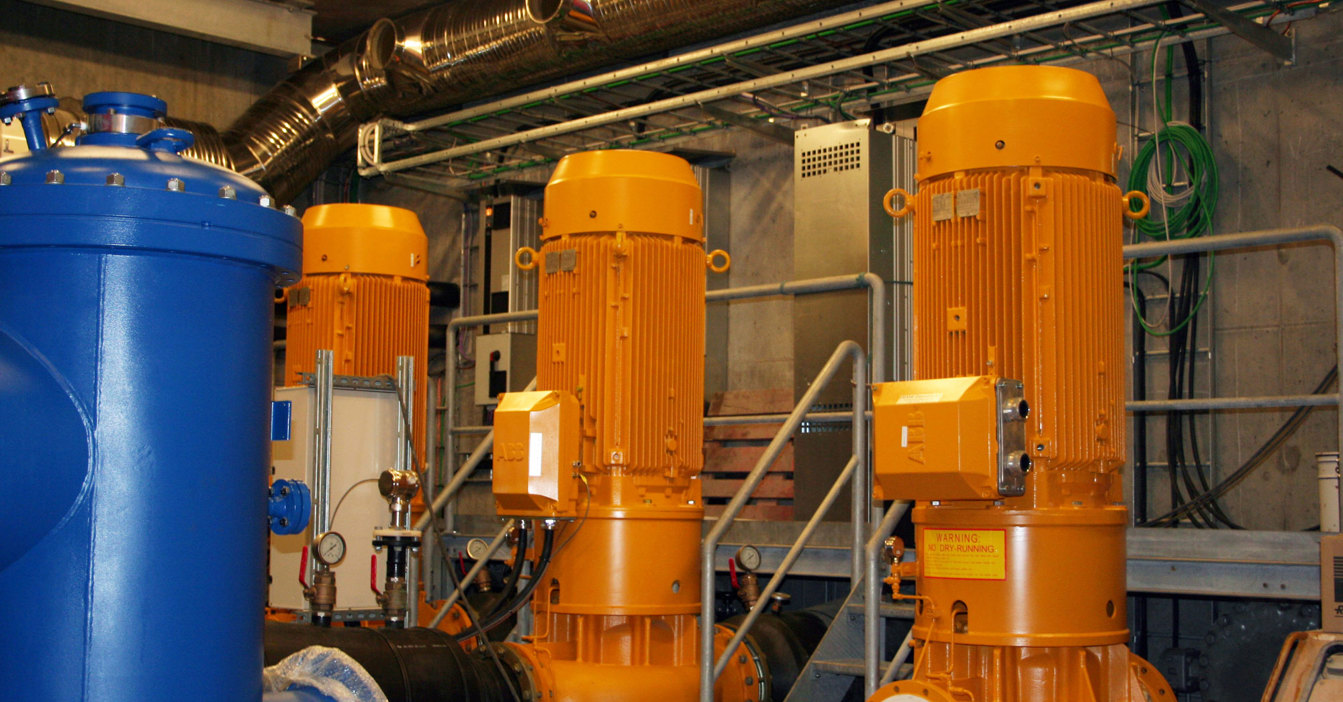 Orange DESMI industrial pumps in a facility for fluid handling operations.