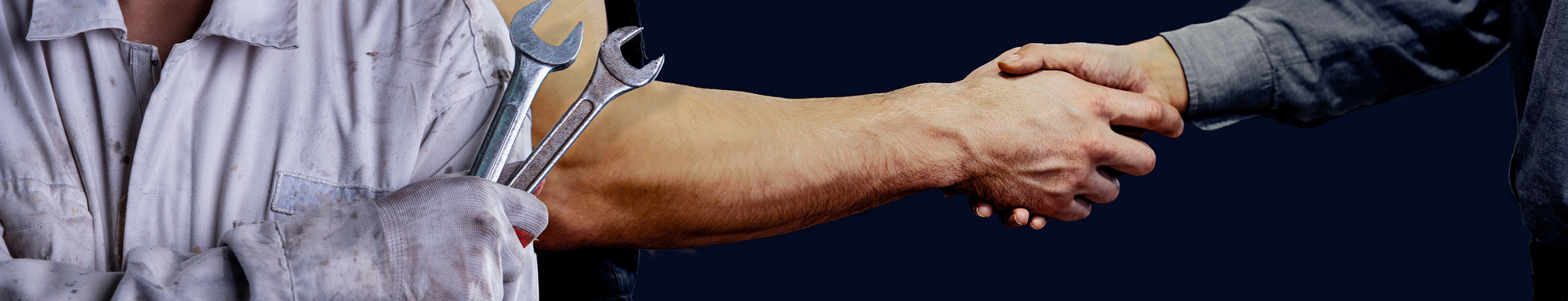 Mekaniker som håller i skiftnycklar och skakar hand med en annan person i överenskommelse.