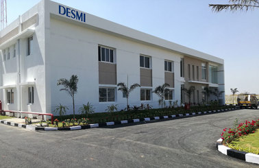 Modern DESMI building with landscaped surroundings and a clear blue sky.