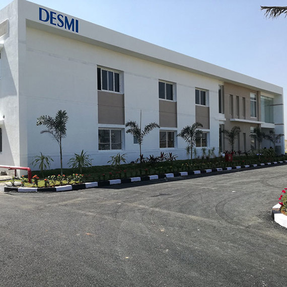 Modern DESMI building with landscaped surroundings and a clear blue sky.