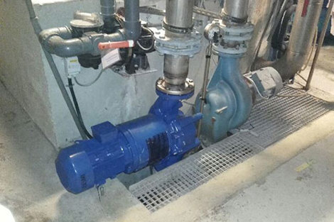 Industrial pump system installed with connected piping for fluid handling.