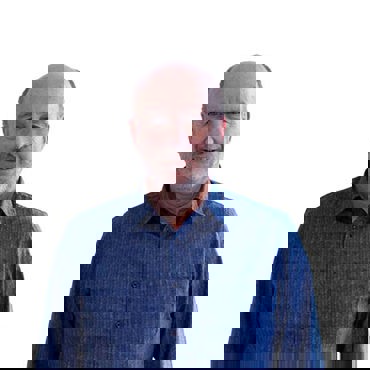 穿蓝色衬衫的微笑男子，背景为纯白色。