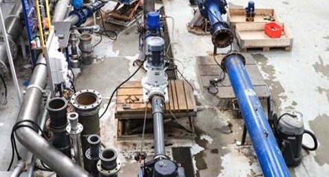 Industrial facility with large pipes and DESMI pumps for fluid handling.