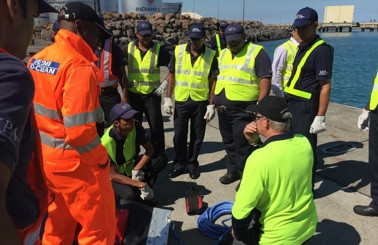 Team in safety gear conducting a DESMI training session by the waterfront.