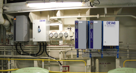 DESMI OptiSave energy-saving system with gauges and control panels for fluid handling.