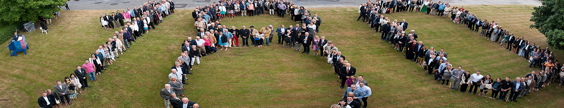人们在草地上排列成“100”字形拍照。
