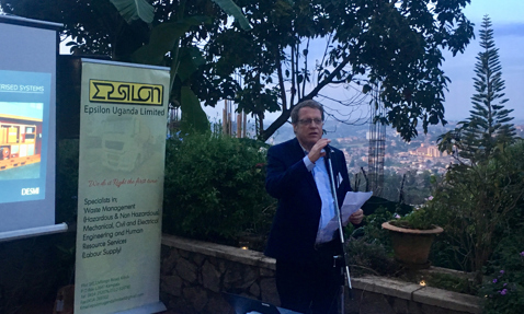 Man speaking at outdoor event with Epsilon Uganda Limited and DESMI presentations.