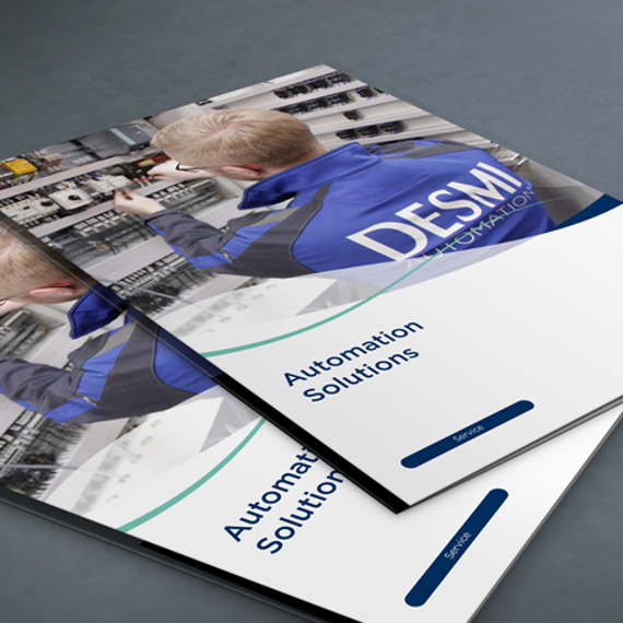 Brochures titled "Automation Solutions" featuring DESMI branding on a gray surface.