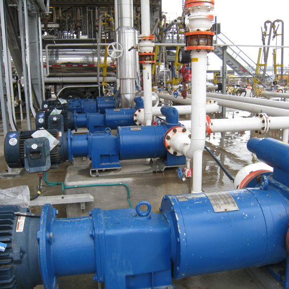 Pompes DESMI bleues dans une installation industrielle pour opérations de manipulation de fluides.
