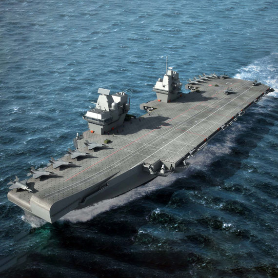 Aircraft carrier sailing on the ocean with fighter jets on deck.