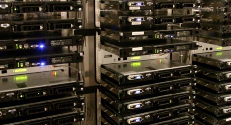 Rows of stacked servers with illuminated indicator lights in a data center.