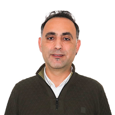 Smiling person wearing a dark sweater against a white background.