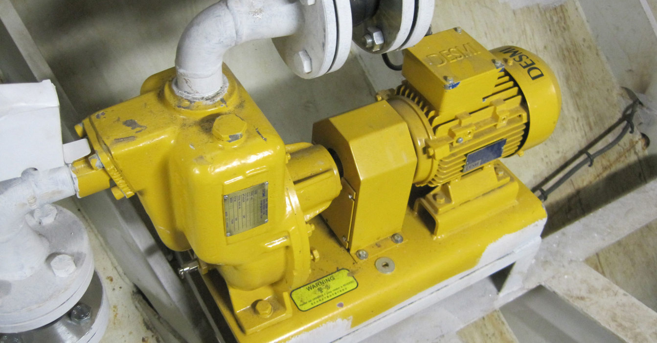工业环境中用于流体处理的黄色DESMI泵连接到管道。