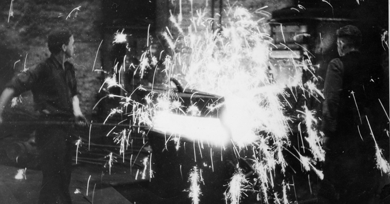 Men working with sparks flying in an industrial setting.