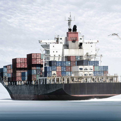 Großes Frachtschiff beladen mit bunten Containern, segelt auf ruhigem Meer.