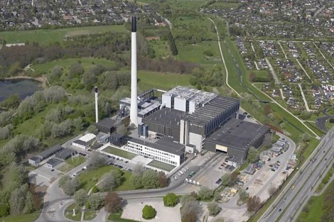 Aerial view of a large industrial facility surrounded by greenery and roads.