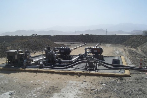 Industrial pump setup in a desert landscape for fluid handling operations.