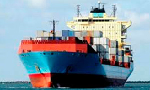 Large cargo ship loaded with colorful containers sailing on the ocean.
