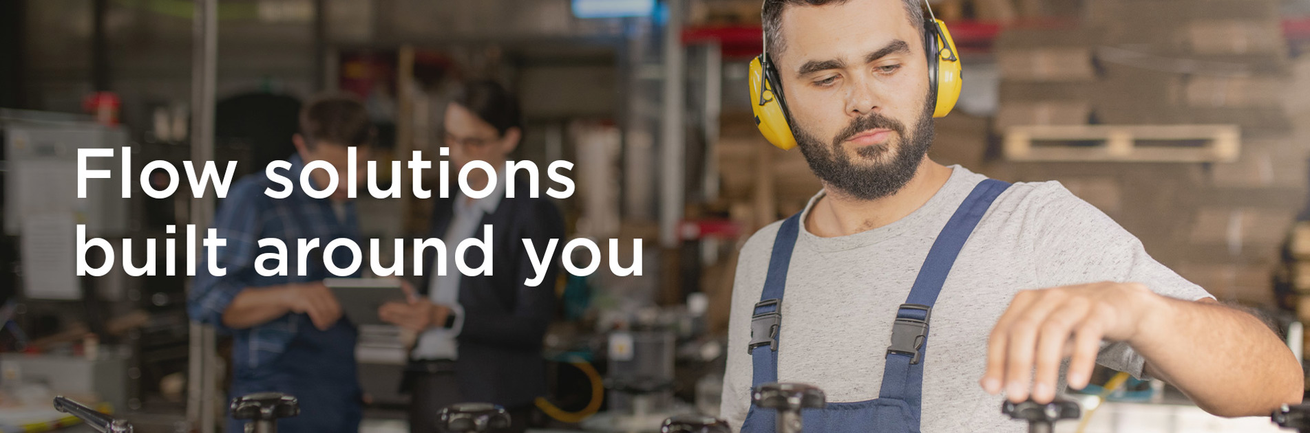 Worker in overalls and ear protection, with text: "Flow solutions built around you."