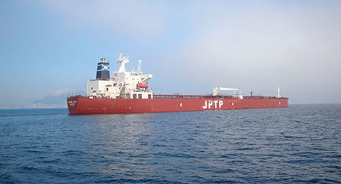Large red cargo ship labeled "JPTP" sailing on a calm sea.