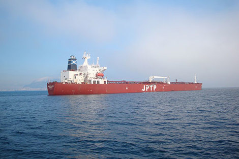 Large red cargo ship labeled "JPTP" sailing on a calm sea.