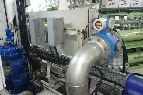 Industrial machinery setup featuring piping, control panels, and H.F.O. heaters in a facility.