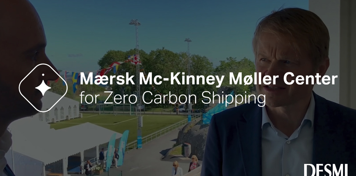 Two men talking at Mærsk Mc-Kinney Møller Center event. DESMI logo visible.
