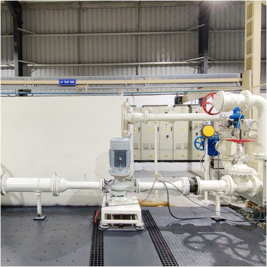 Industrial pump system with pipes and valves in a large facility setting.