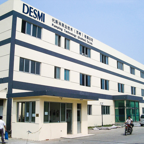DESMI Pumping Technology building with people walking and a motorcycle in front.
