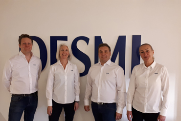 Marinfartyg med helikopter som svävar ovanför däck till sjöss.