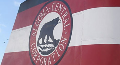 Algoma Central Corporation logo on ship's funnel against a blue sky.