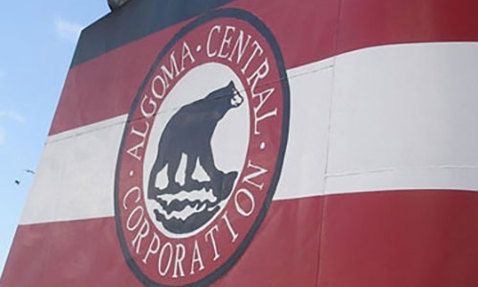 Logo di Algoma Central Corporation sul fumaiolo della nave contro un cielo azzurro.