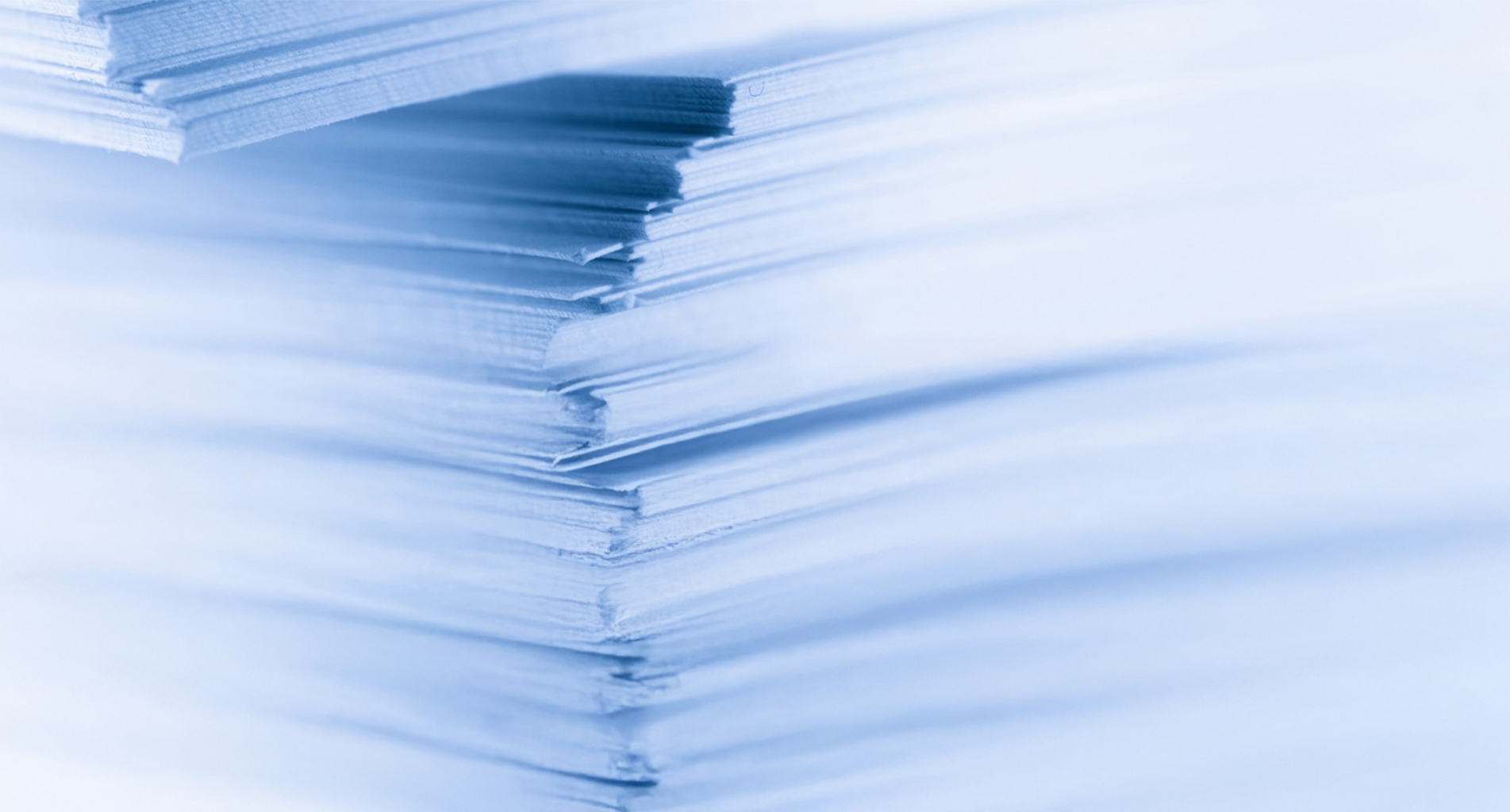 Primo piano di fogli di carta impilati con una leggera tonalità blu.