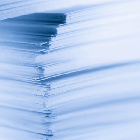 Close-up of stacked paper sheets with a soft blue tint.