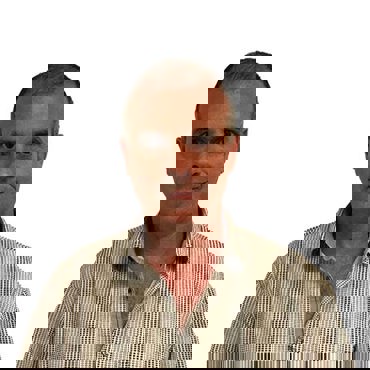 Man in a checkered shirt smiling slightly against a white background.