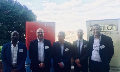 Six men in suits stand in front of DESMI and Epsilon Uganda banners.