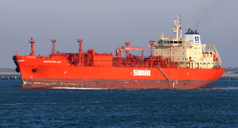 Red LPG tanker "Navigator Leo" sailing on the ocean under clear skies.