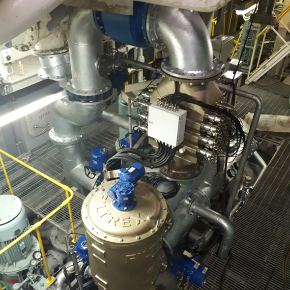 Industrial machinery with pipes and a large Filtrex unit for fluid handling.