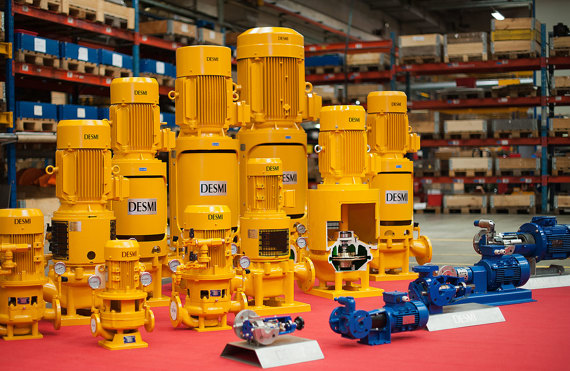 Yellow DESMI pumps for fluid handling displayed in a warehouse setting.