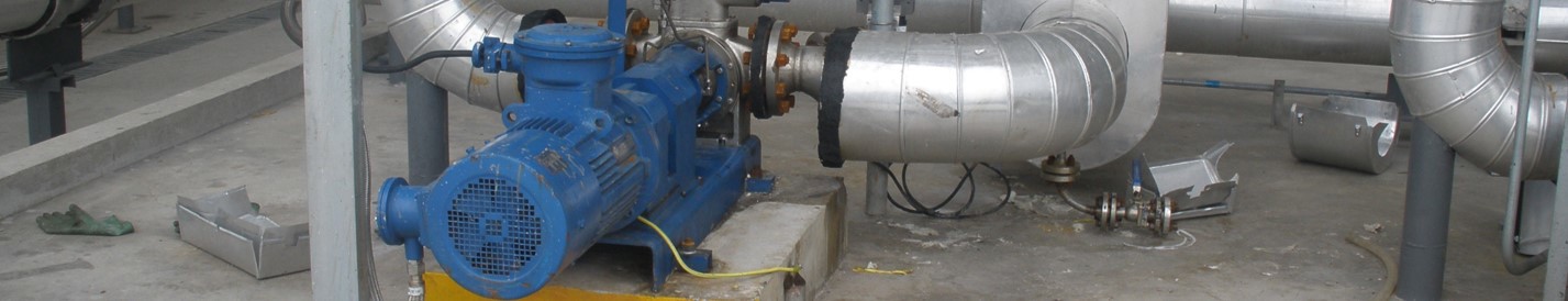 混凝土地面上的蓝色工业泵连接到大型银色管道。