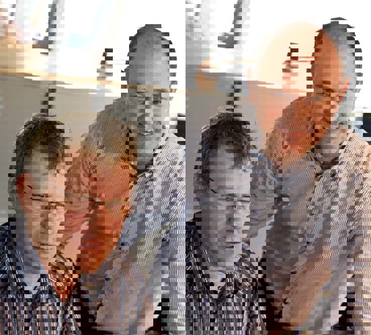 Two men in striped shirts collaborating in an office setting.