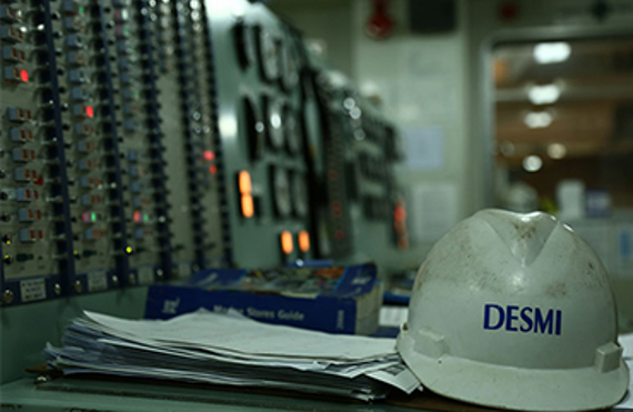 DESMI安全帽放置在工业环境中的控制面板桌上。